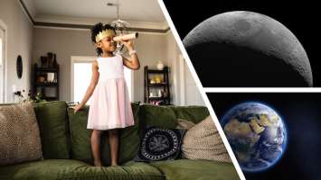 Une petite fille regarde à travers une petite lunette et ce qu'elle voit c'est la lune et la terre dans l'espace Une petite fille regarde à travers une petite lunette et ce qu'elle voit c'est la lune et la terre dans l'espace